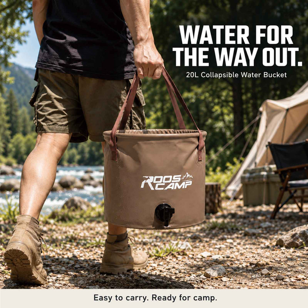 Person carrying the Roos Camp 20L collapsible water bucket by its reinforced handles at a riverside campsite