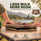 Roos Camp 20L collapsible water bucket being folded flat on a camping table for compact storage