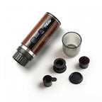 RoosCamp Pocket Esso brewing espresso – rich crema pouring into ribbed glass cup from portable self-heating coffee machine
