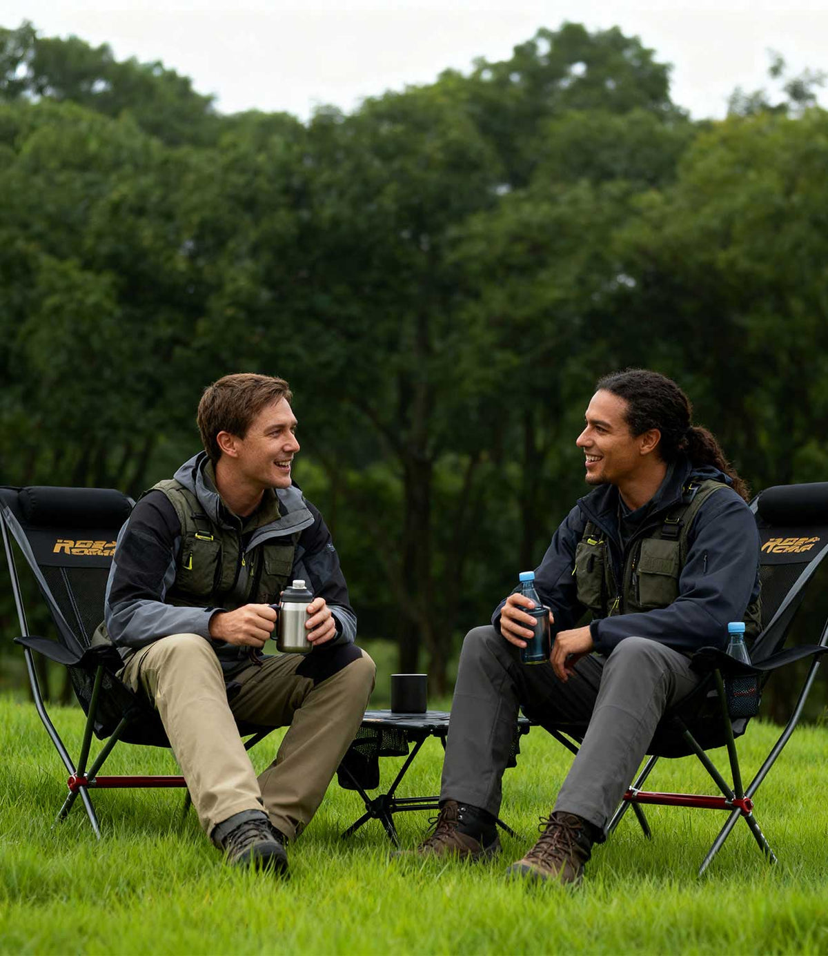 Two men laughing and relaxing in RoosCamp High-Back Camping Armchairs outdoors with drinks
